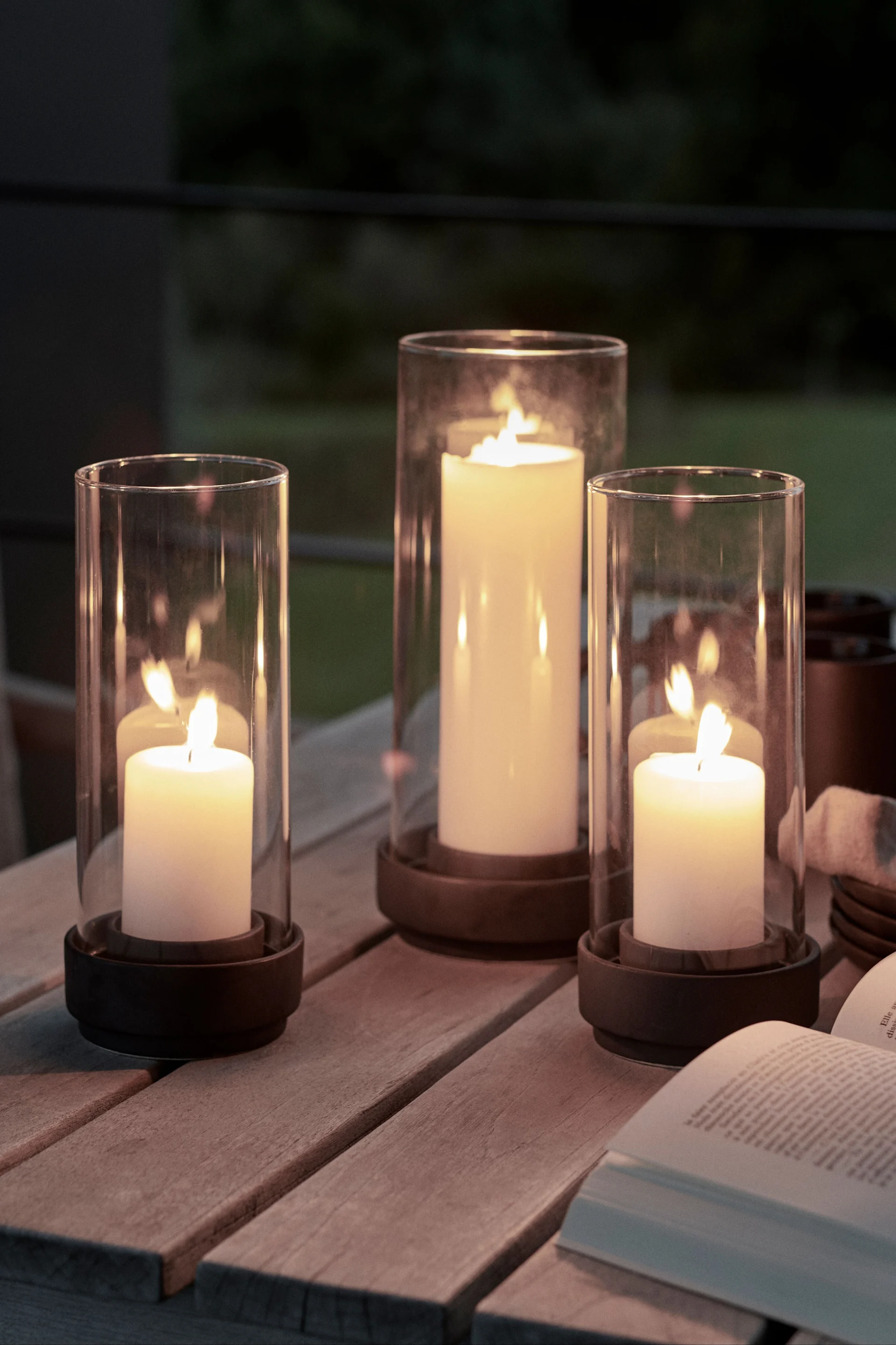 Decoreer je tuintafel met buitenlantaarns en windlichten in verschillende maten om de gezelligheidsfactor te verhogen. De Hurricane lantaarns van Stelton zijn hier bijzonder geschikt voor.