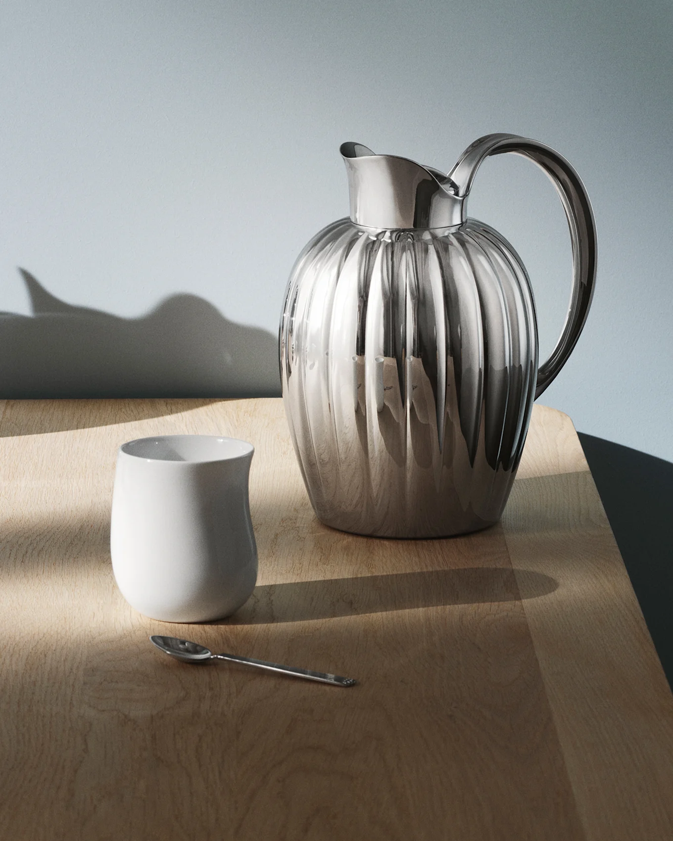Een glimmende, geribbelde zilveren kan met handvat op een donkere, reflecterende tafel, met lichtpatronen.