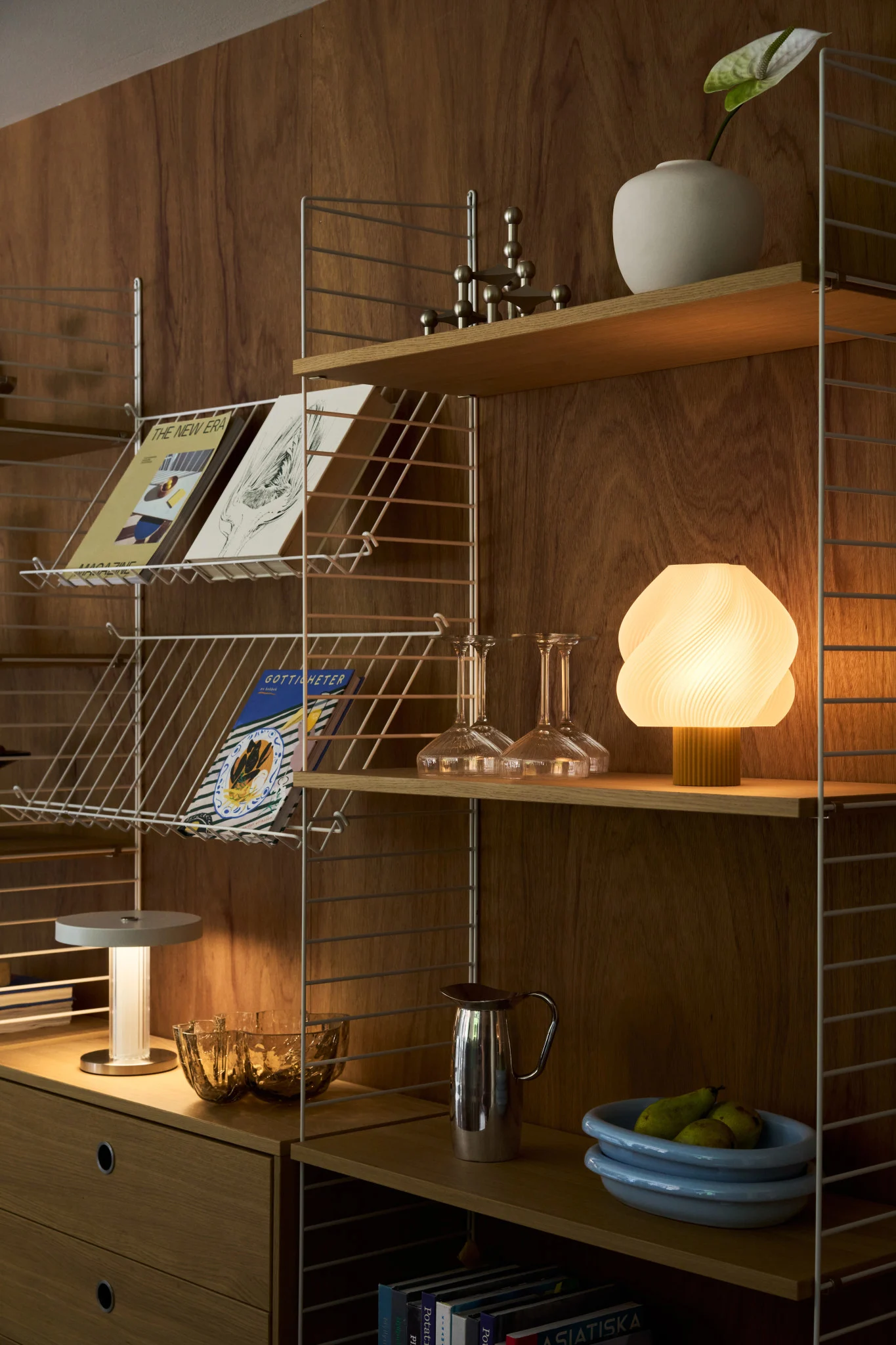 Denk erover na om meerdere lichtbronnen te gebruiken bij het plannen van je verlichting. Hier zie je een eettafel met veel verschillende tafellampen en een dramatische plafondlamp. 
