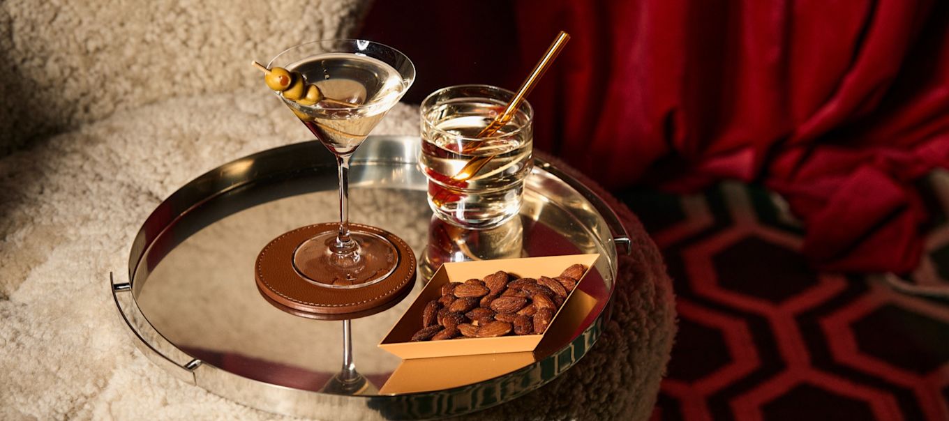 Verschillende soorten cocktailglazen: Welk glas voor welke cocktail? Hier zie je een martiniglas en een tumbler op een weerspiegelend dienblad van Spiegelau. 