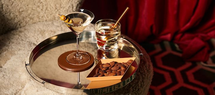 Verschillende soorten cocktailglazen: Welk glas voor welke cocktail? Hier zie je een martiniglas en een tumbler op een weerspiegelend dienblad van Spiegelau. 