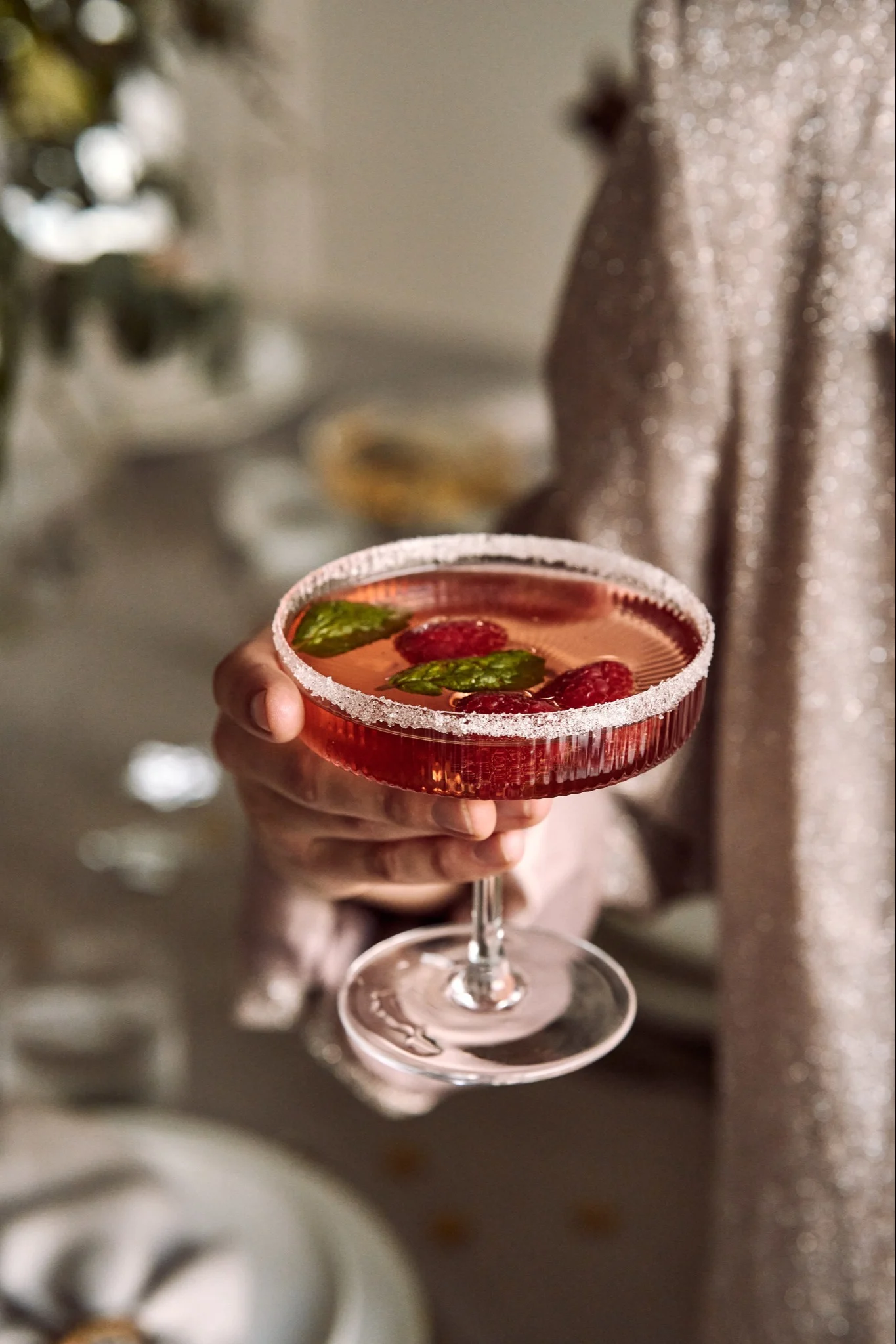 Verschillende soorten cocktailglazen: Welk glas voor welke cocktail? Hier zie je een hand die een Ripple champagneglas van ferm LIVING vasthoudt.
