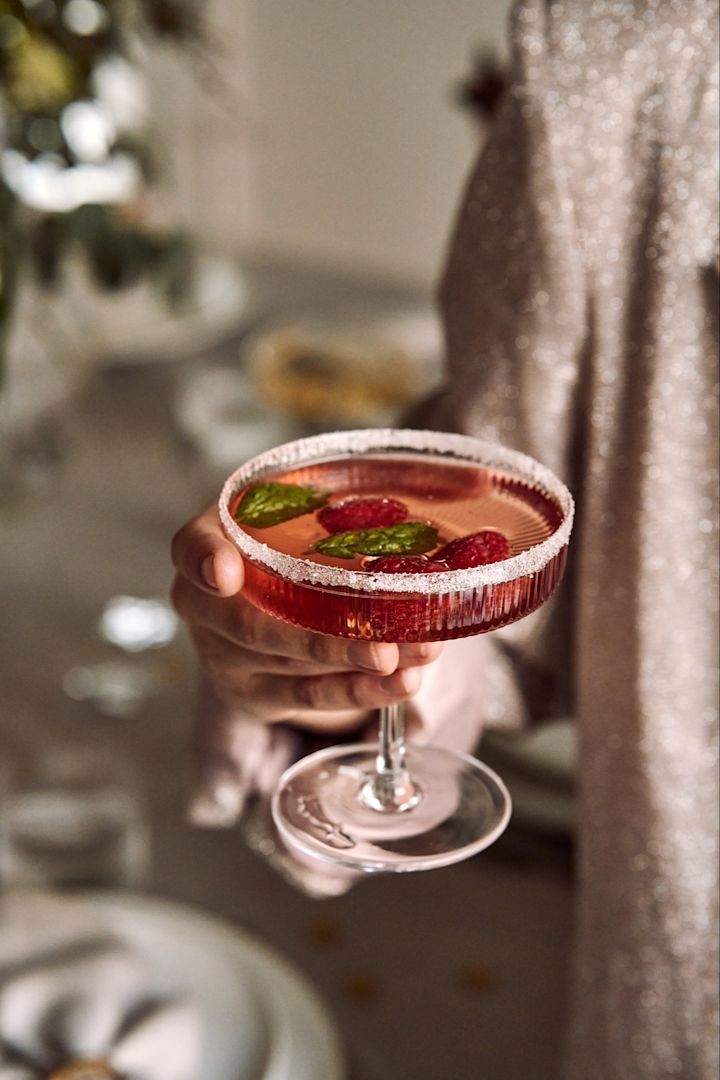 Verschillende soorten cocktailglazen: Welk glas voor welke cocktail? Hier zie je een hand die een Ripple champagneglas van ferm LIVING vasthoudt.