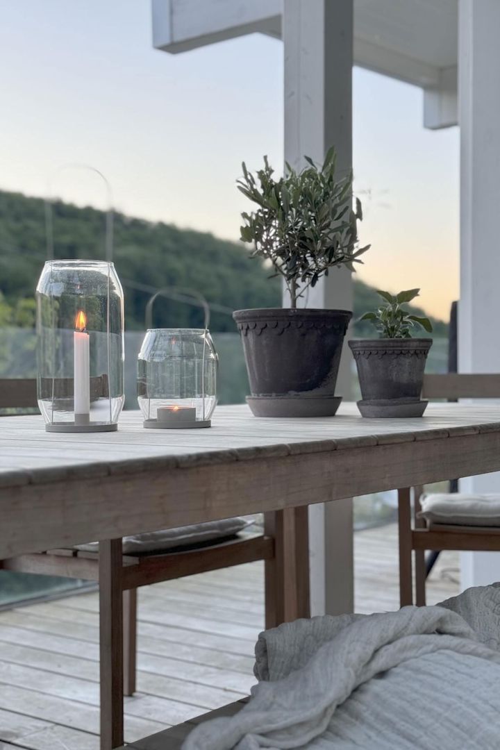 Twee grijze bloempotten van Copenhagen staan op een tafel, naast twee Ernst lantaarns in verschillende maten op het terras van @zuhauselig.