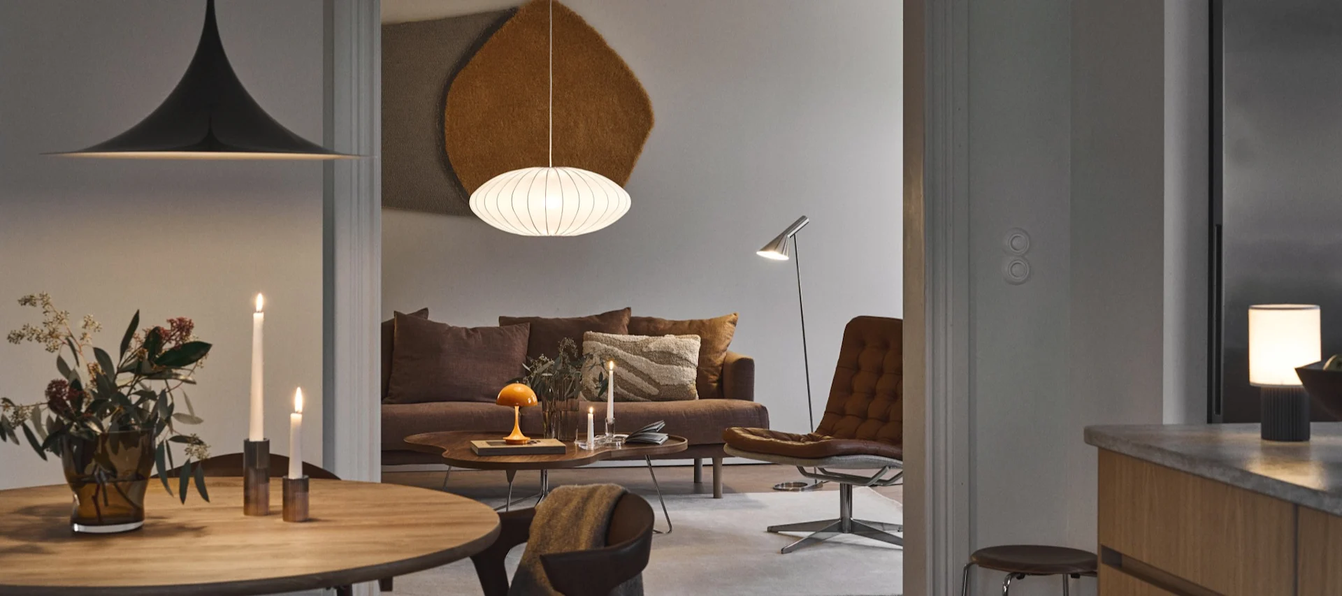 Het kiezen van de juiste lamp is belangrijk voor het gevoel in je huis - een man die op een bank zit, omringd door verschillende lichtbronnen, en een boek leest. 