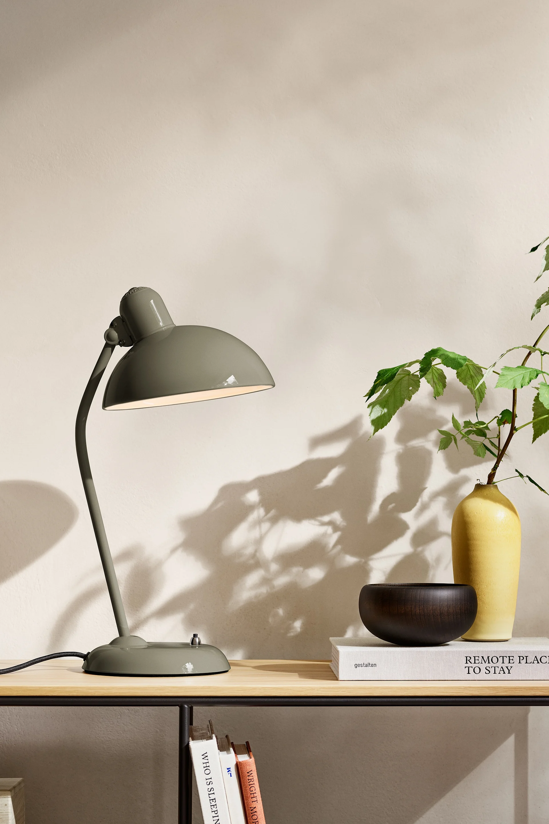 Tot de interieurtrends voor 2025 behoort een natuurlijke tint olijfgroen; hier zie je de Kaiser Idell lamp van Fritz Hansen op een dressoir staan.