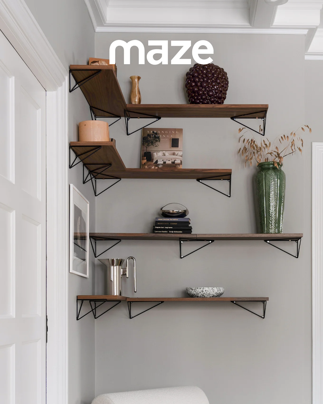 Witte boomvormige kapstok met houten knoppen in een kinderkamer met wieg en speelgoed. Merk 'maze' is zichtbaar.