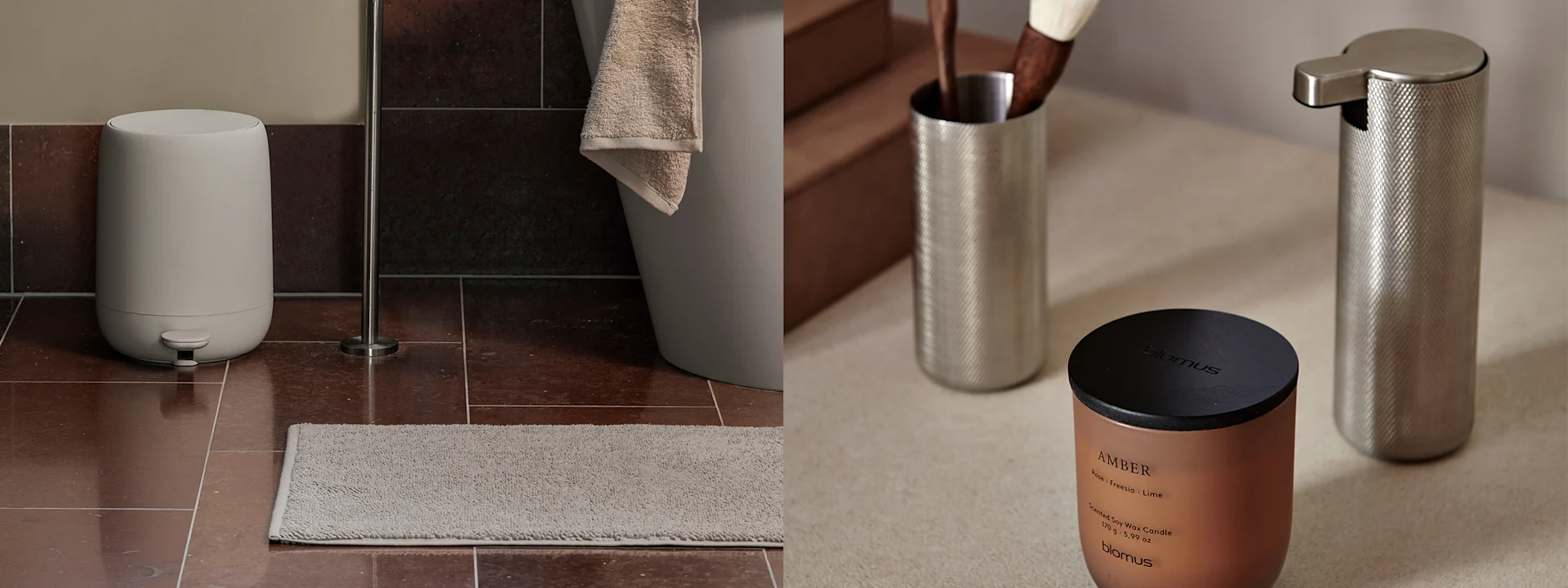 Bruine marmeren badkamermeubel met een zwarte kraan, grijze handdoek en zwarte accessoires. Een zwarte plank erboven bevat zwarte flessen. Rechts een koperen kaars en zilveren dispensers.