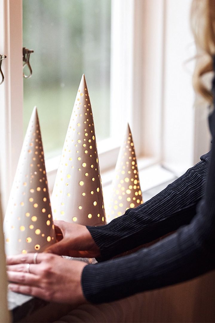De lantaarns van Kähler in de vorm van kerstboompjes zijn prachtige kerstdecoraties op de vensterbank.