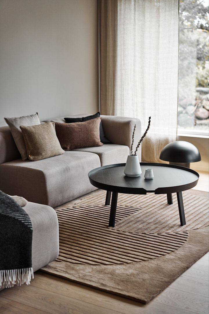 Decoreer je woonkamer met gezellige vloerkleden - hier zie je het beige wollen vloerkleed Circles van NJRD in een beige woonkamer.