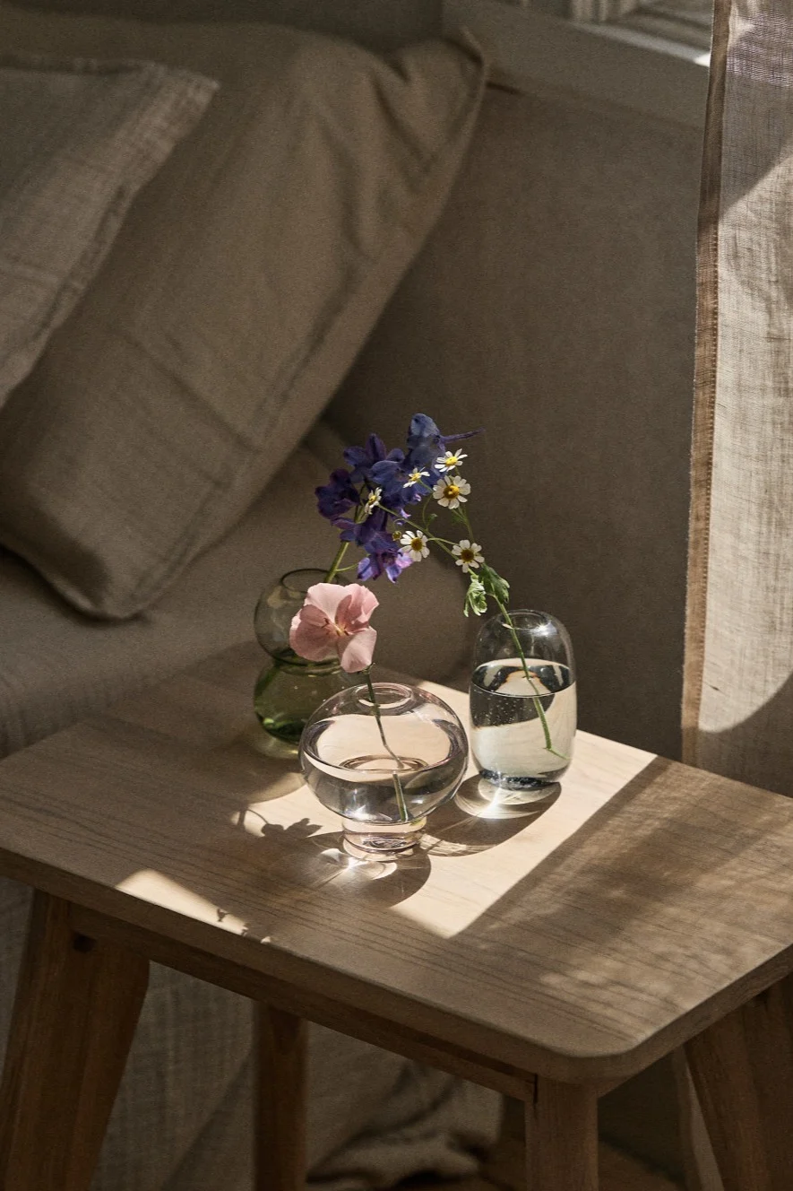 Verschillende kleine vaasjes voor losse bloemen of kleine boeketjes staan op een vensterbank. 