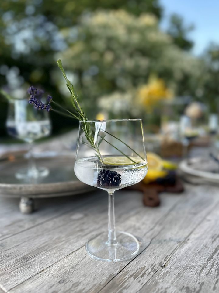 Een gin en tonic type cocktailglas met een cocktail en limoen. 