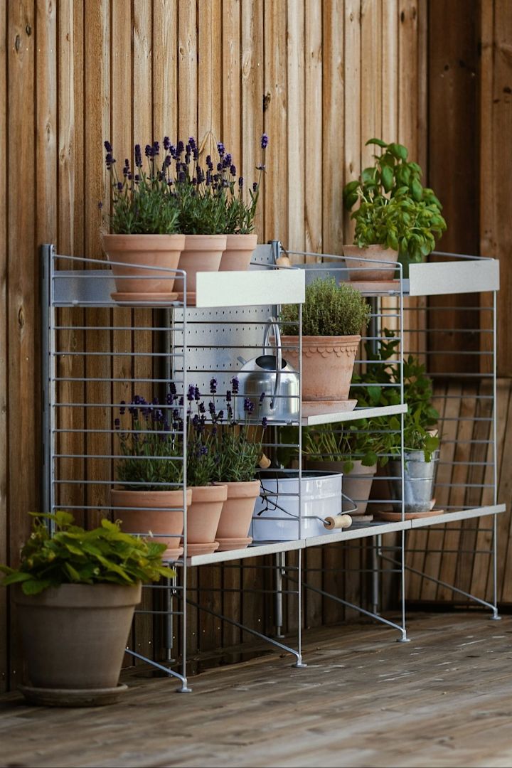 Een buitenplank van String staat op het terras van @applaudden, gevuld met verschillende planten in bloempotten van Bergs Potter uit de collectie van Kopenhagen.