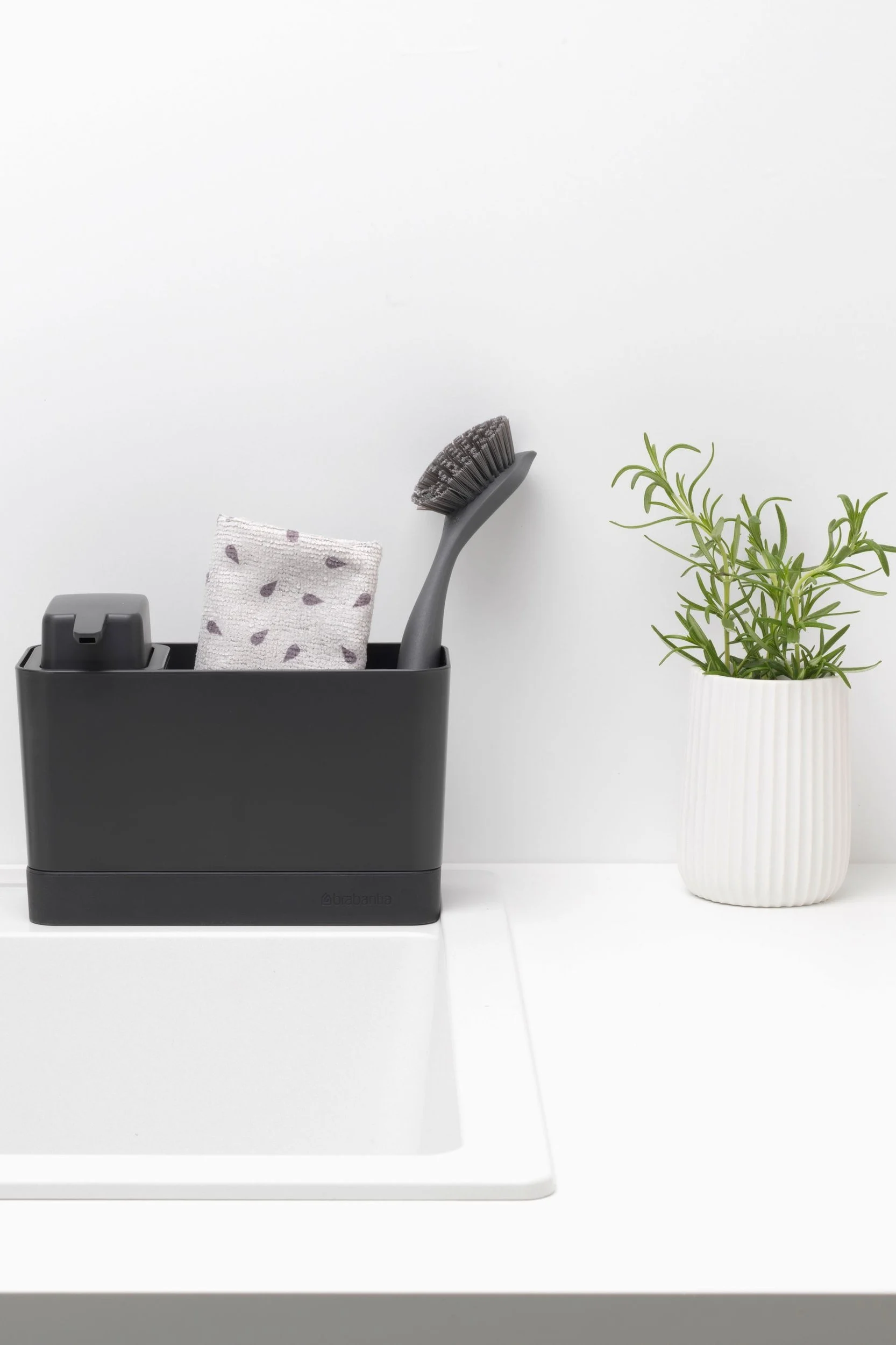 Maak je koekenpan schoon met de Brabantia gootsteenorganiser, die een zeepdispenser, vaatdoek en afwasborstel bevat.