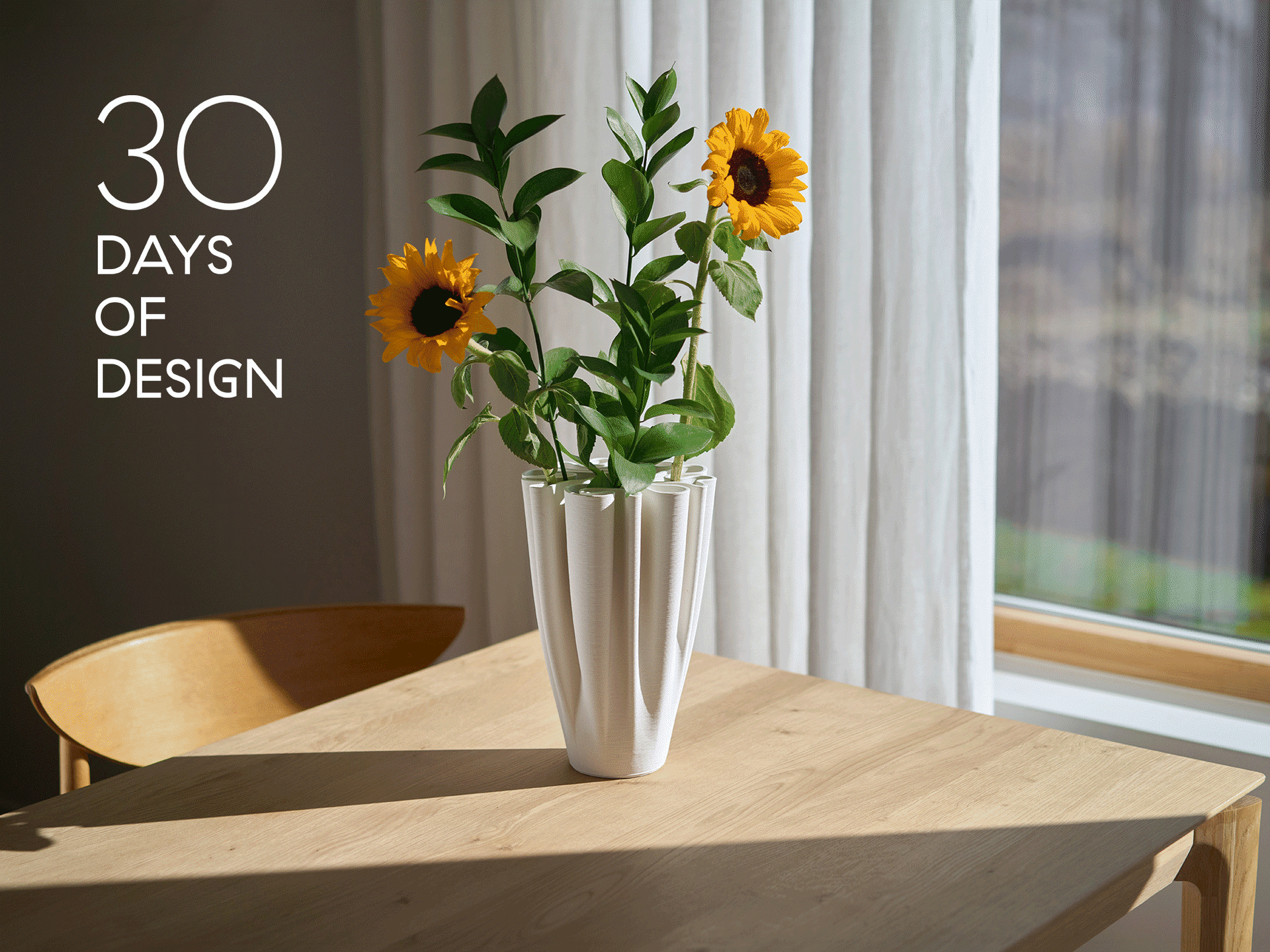 Witte geplooide vaas met zonnebloemen op een houten tafel. Tekst luidt '30 DAYS OF DESIGN'.