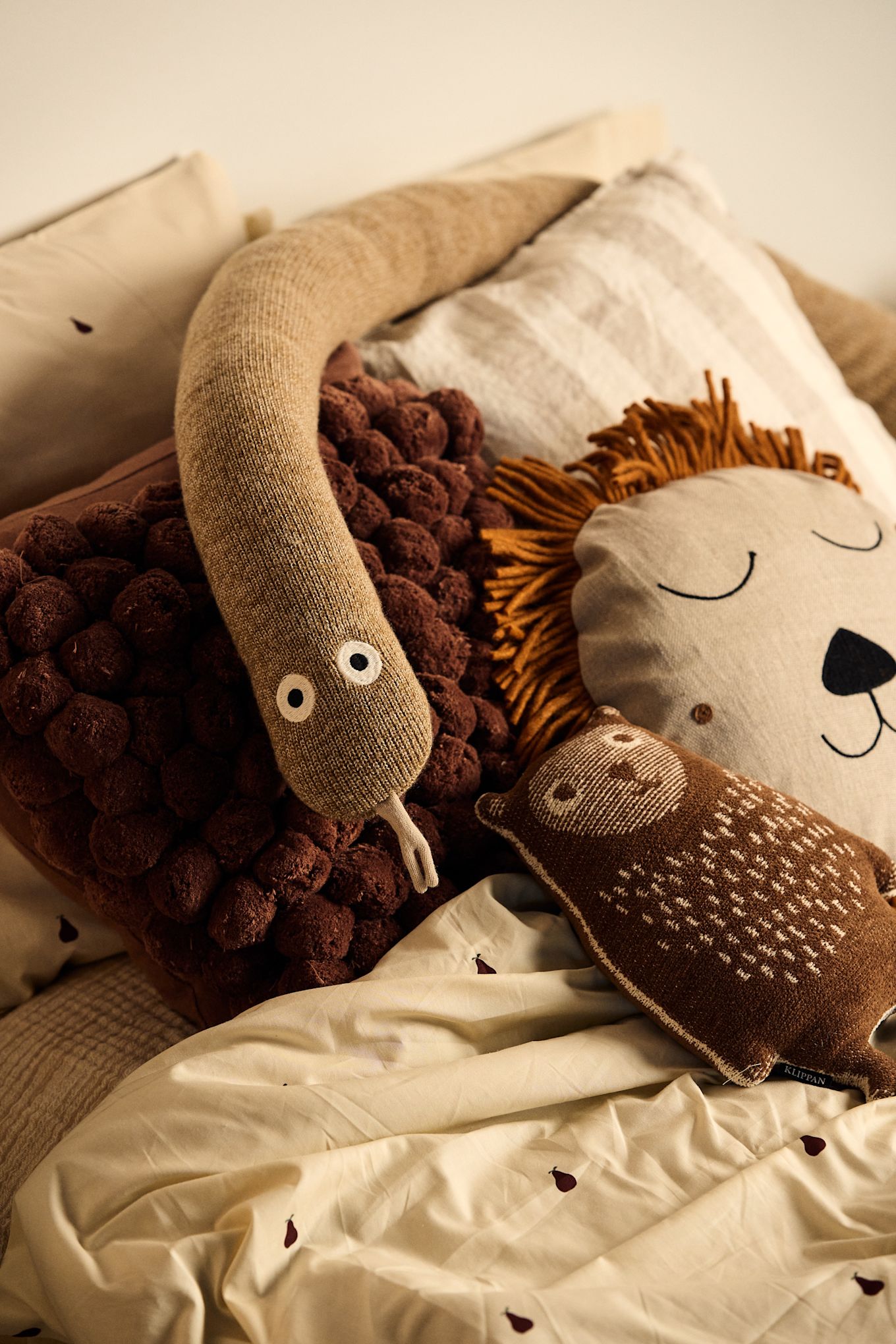 Zorg ervoor dat de kamer van je kind speels is ingericht. Hier zie je een slang en een leeuwenkussen op het bed van een kind. 
