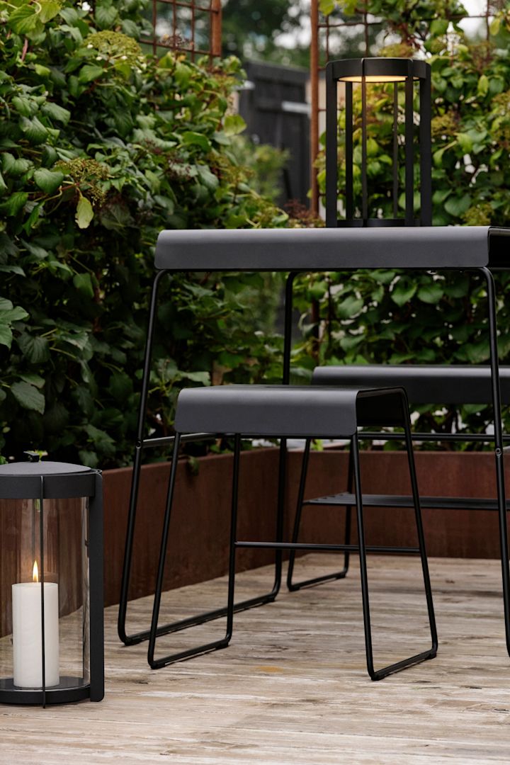 De tafel en kruk uit de outdoor collectie van Zone Denmark staan buiten op een terras.