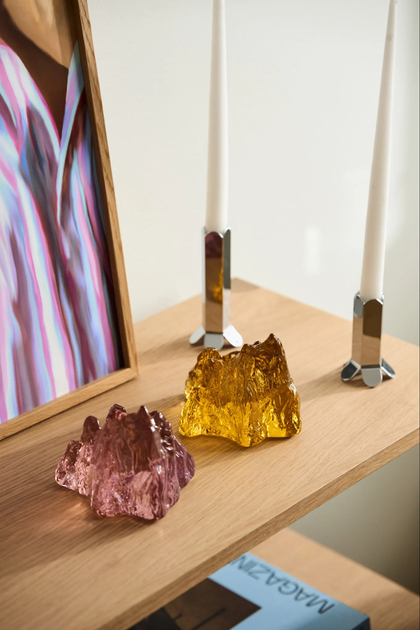 Kerstcadeaus tips:  hier zie je twee kaarsenhouders uit de Calore collectie van Byon op een bijzettafel staan met een vaas erachter.