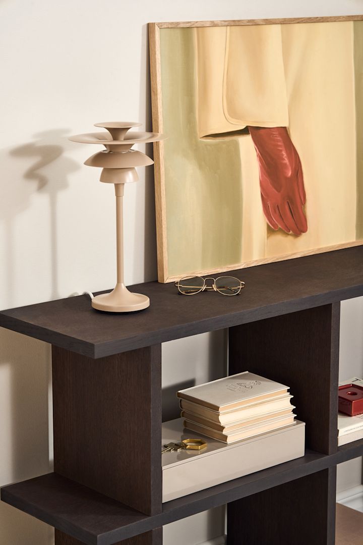 Breng lagen aan in de verlichting in de eetkamer. Hier zie je de Picasso tafellamp in beige van Belid op een bijzettafel. 