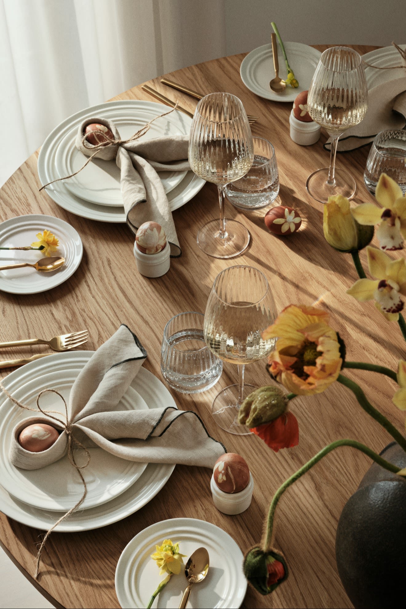 De eettafel is gedekt met servies, glazen en bestek van Broste Copenhagen, de servetten zijn gevouwen in de vorm van konijnenoren.