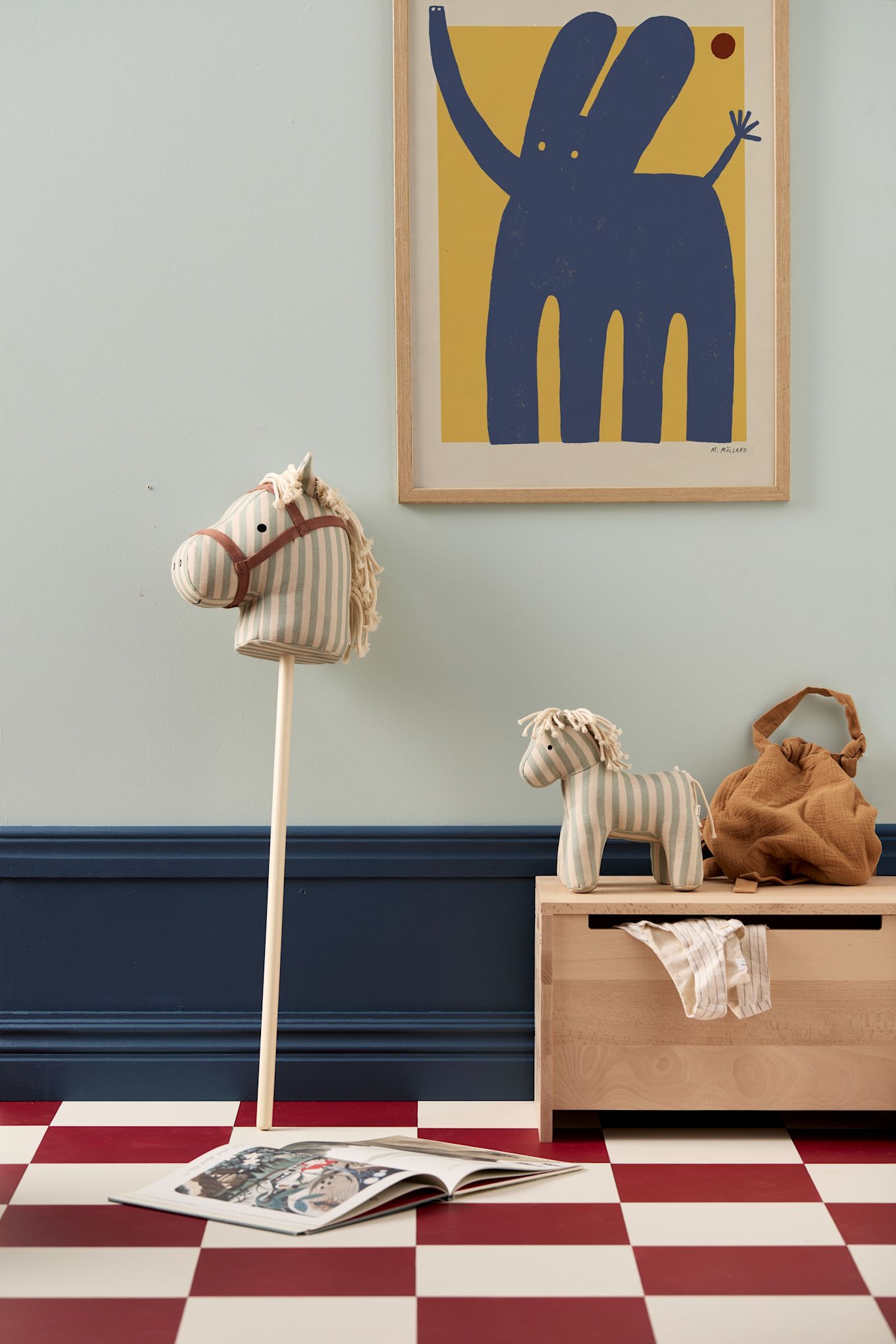 Houten meubels zijn een geweldig idee voor de kinderkamer, hier zie je de houten opbergbox Saga van Kids Concept met een houten stokpaardje. 