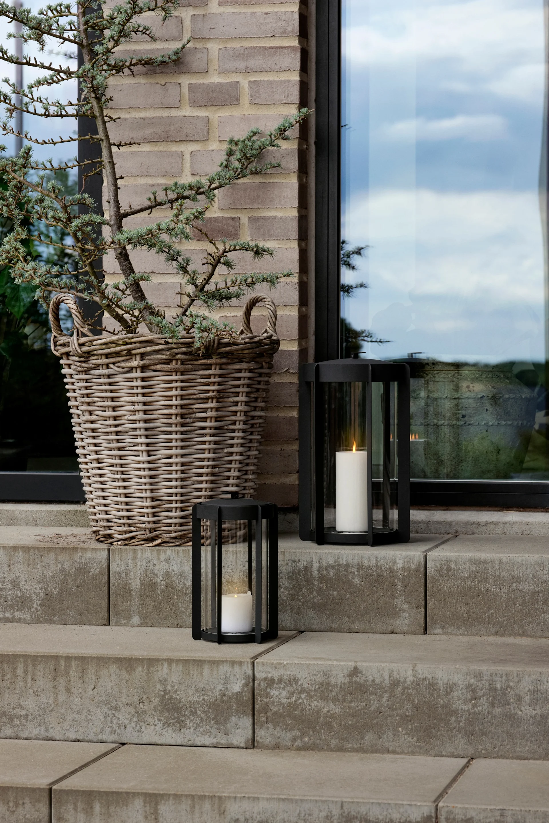 Decoreer je buitentrap met lantaarns en windlichten voor buiten, bijvoorbeeld met de Light'In lantaarn van Audo Copenhagen.