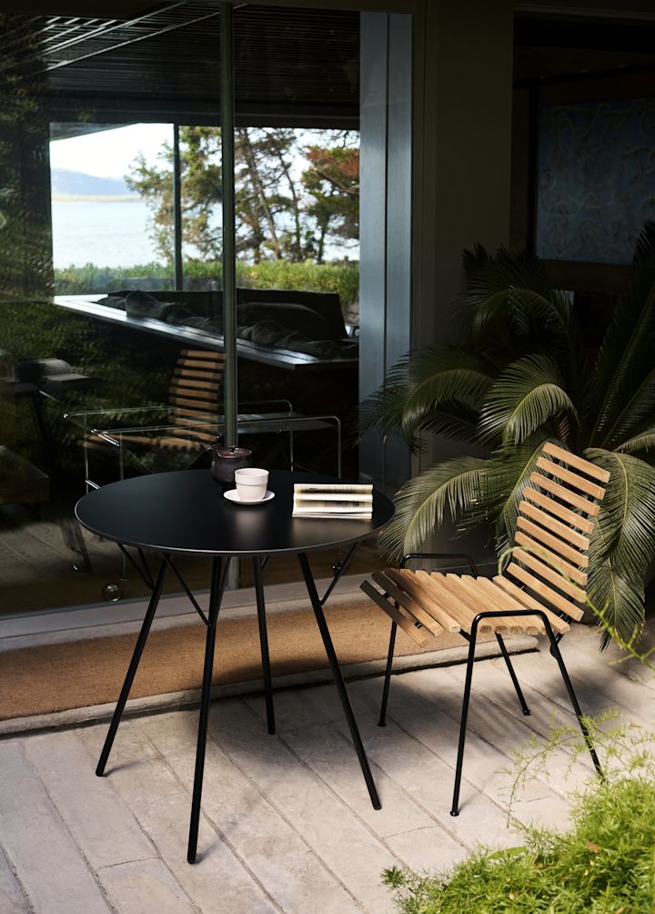 De RFH RD4 terras bijzetstoel van &Tradition staat op een patio met een ronde tafel.