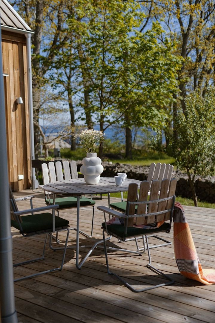 Een kleine, gezellige eethoek op een houten terras met A2 stoelen van Grythyttan.