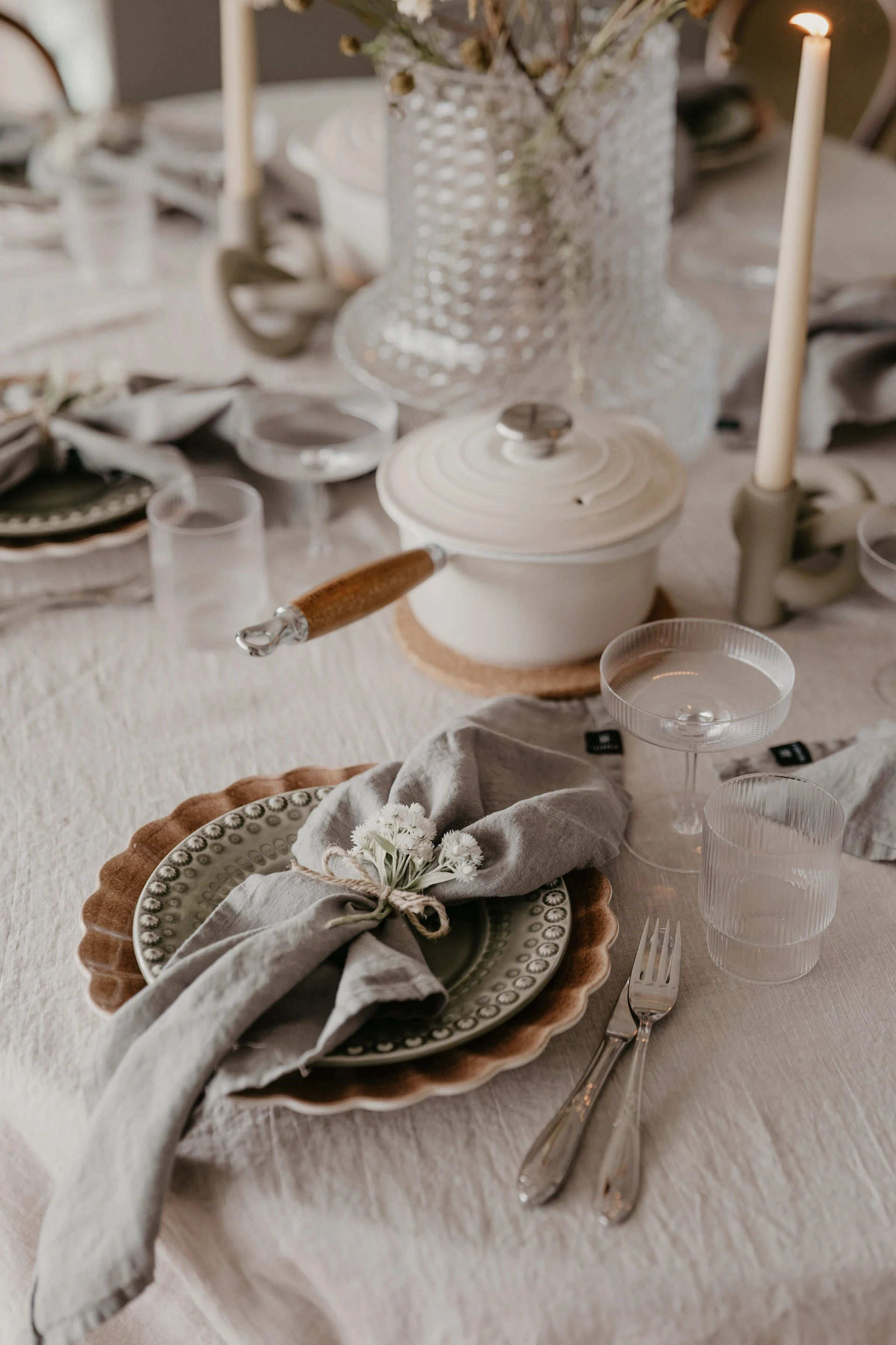 Een gedekte tafel met een bordenenvelop van Mateus en PotteryJo met gedroogde bloemen als decoratie bij Johanna Berglund thuis @snickargladjen.