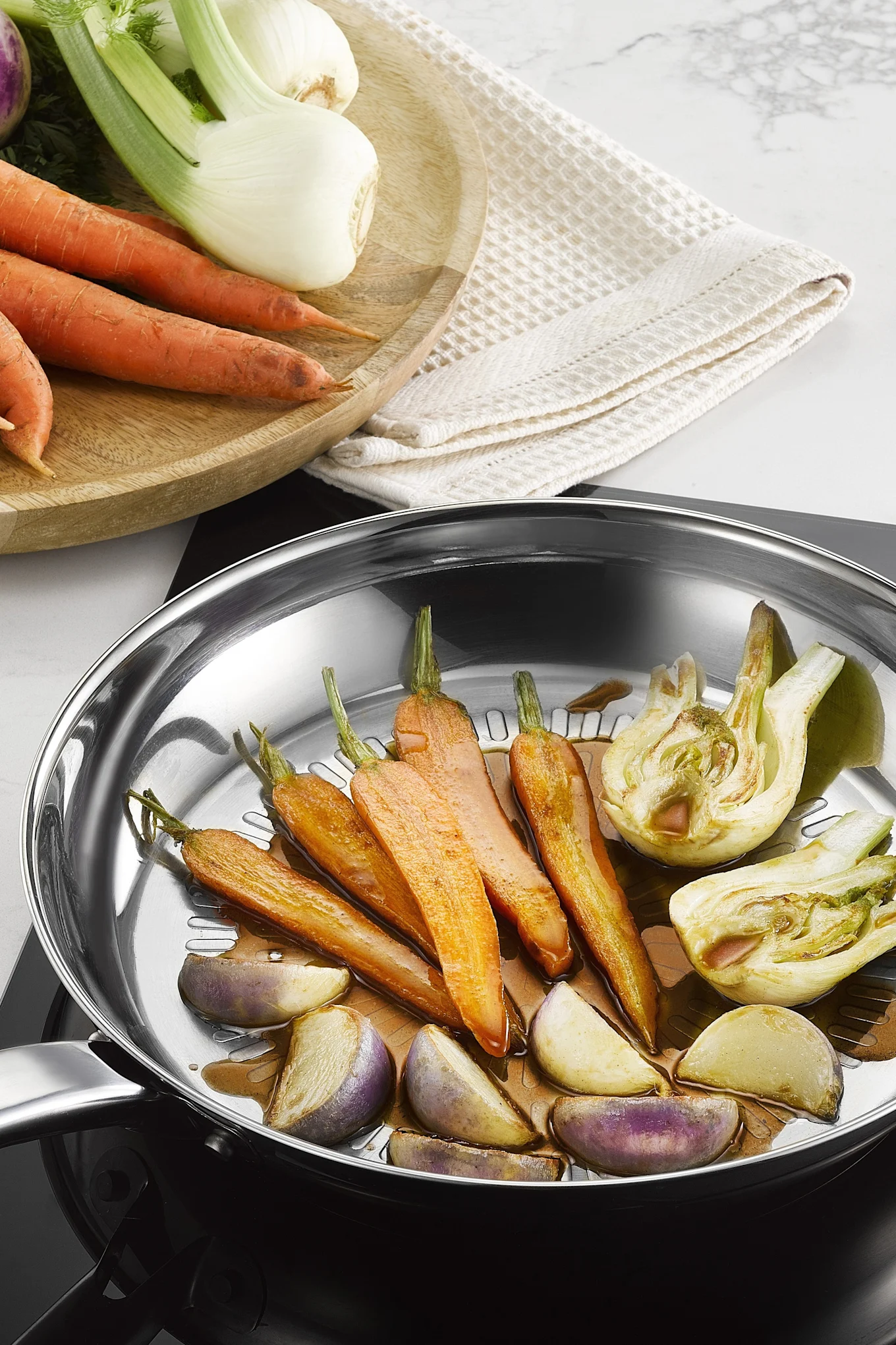 Verschillende groenten worden gebakken in de roestvrijstalen Intuition Techdome pan van Tefal.