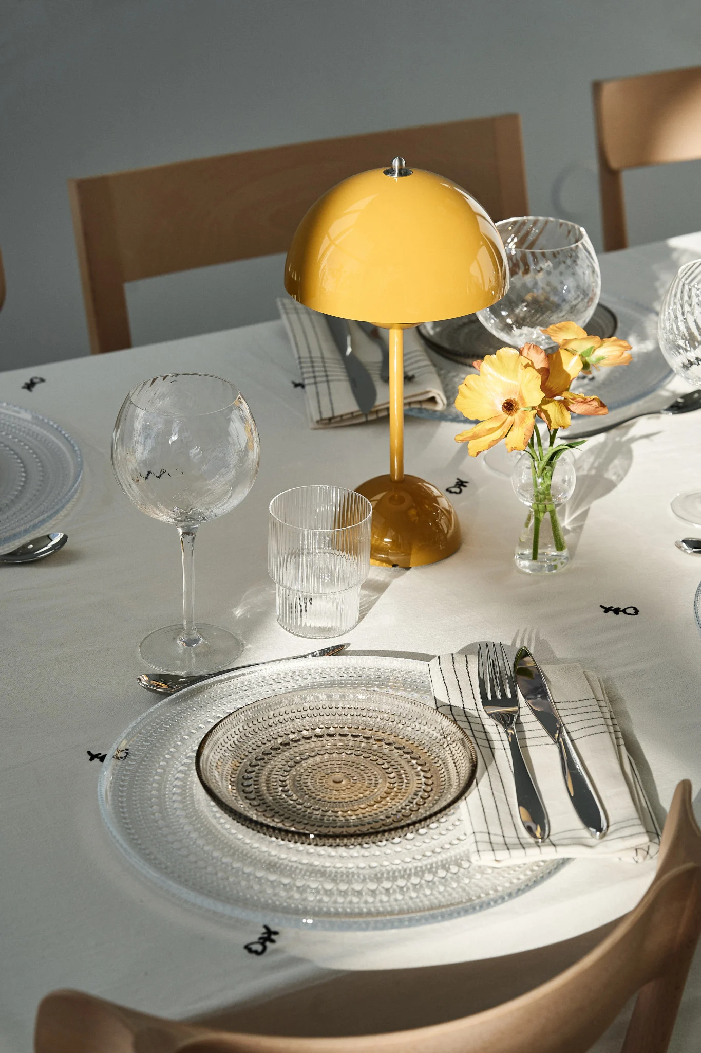 De tafel dekken is een belangrijk onderdeel van elk feest. Hier zie je een feestdecoratie met een draagbare bloempotlamp en feestelijke glazen borden.