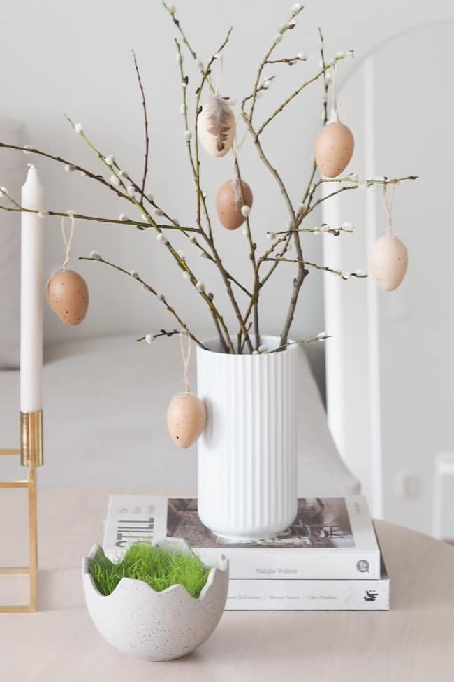 Paasdecoratie: Hier zie je de paasdecoratie van het Instagram-profiel @arkeniestetiikkaa, die bestaat uit de Kubus kandelaar van Audo Copenhagen, de Happy Easter schaal en de Lyngby vaas in wit met lentetakken erin.