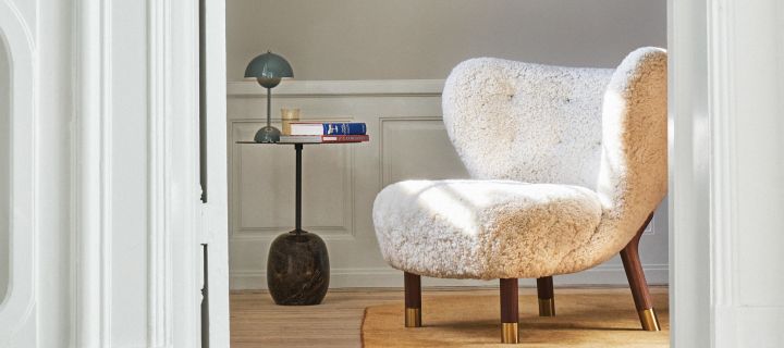 Een woonkamer ingericht met producten van &Tradition, hier zie je de Little Petra fauteuil, de Lato bijzettafel en de VP9 draadloze Flowerpot tafellamp allemaal in donker hout voor een retro gevoel. 