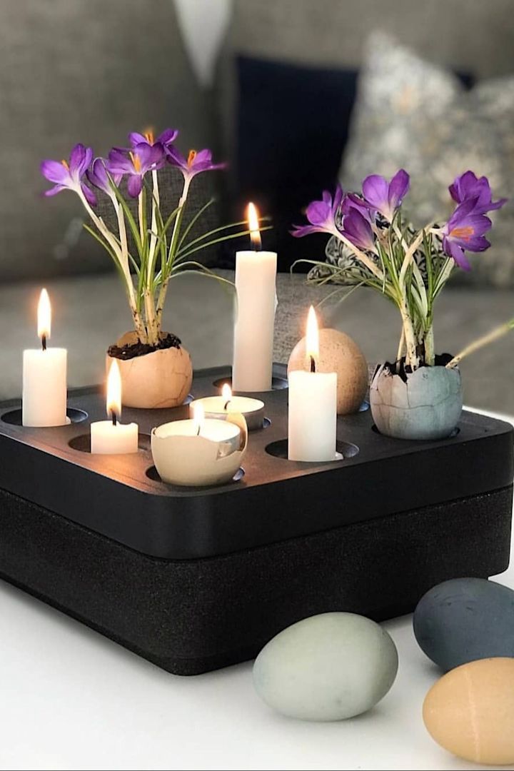 Een zwarte Stumpastaken kandelaar van Born in Sweden is versierd met kaarsen en gekleurde eieren met bloemen erin voor Pasen. @dallasvillan