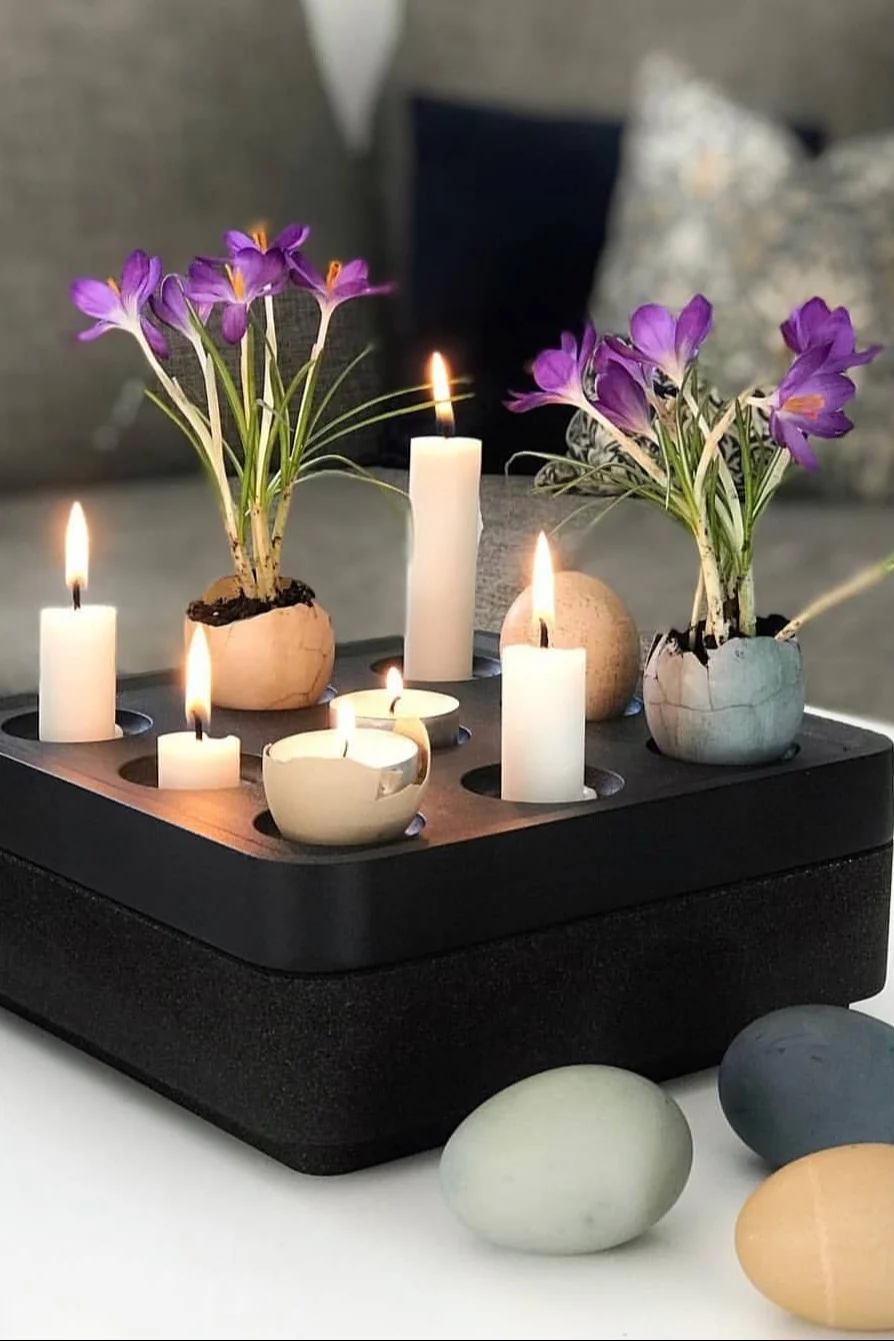 Een zwarte Stumpastaken kandelaar van Born in Sweden is versierd met kaarsen en gekleurde eieren met bloemen erin voor Pasen. @dallasvillan