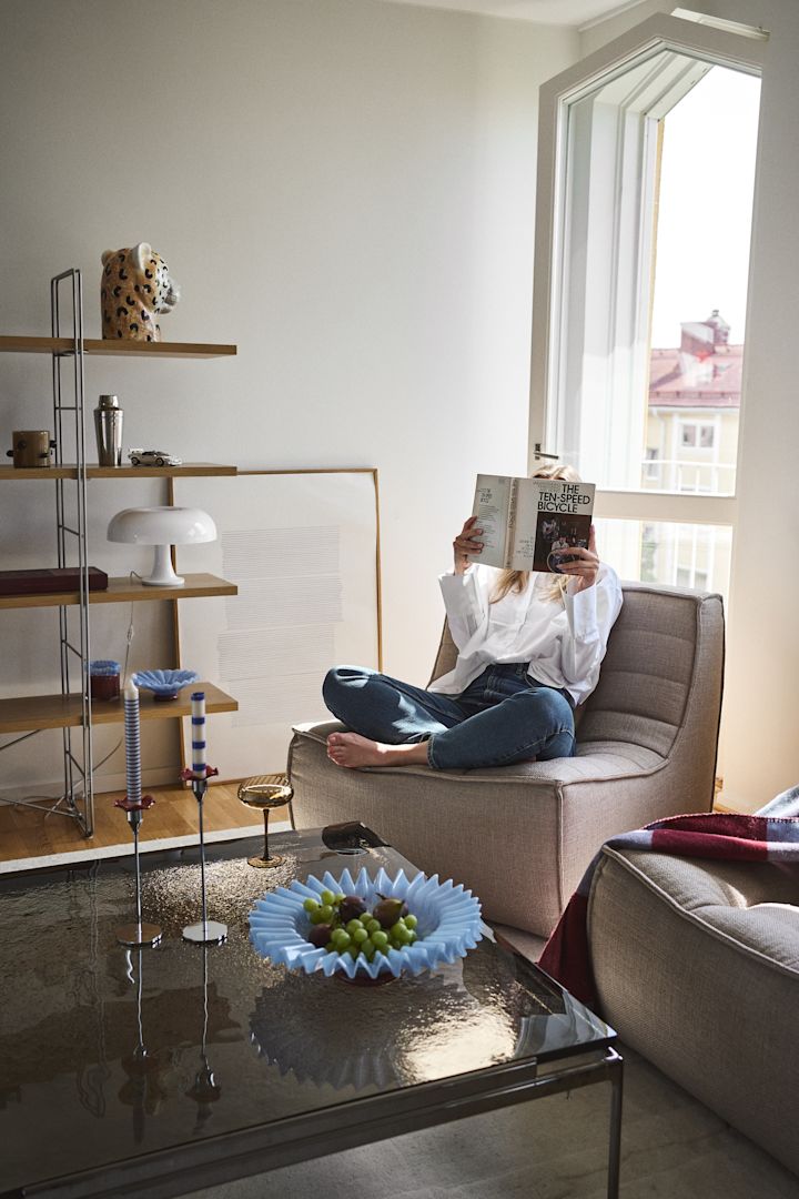 Het inrichten van de woonkamer met statement pieces van Byon creëert een persoonlijk en eclectisch huis, gevuld met vreugde, vorm en kleur. Hier zien we de Lori schaal in lichtblauw, Cheetah vaas, Opacity champagneglazen, Embrace plaid en Lara kaarsenhouder.