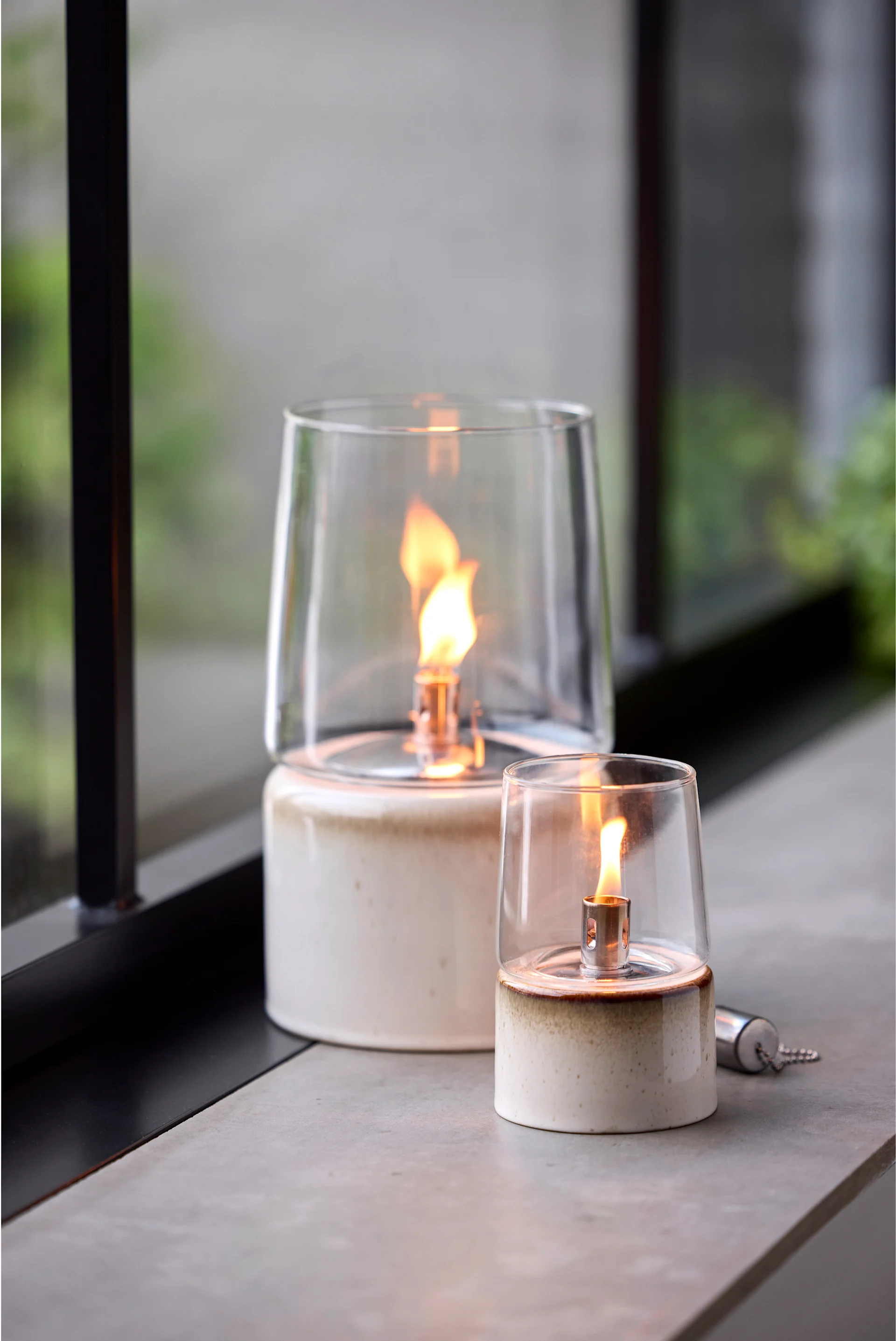 Plaats buitenlantaarns en windlichten op je balkon, terras of in de tuin, bijvoorbeeld de stijlvolle olielamp van Stelton.