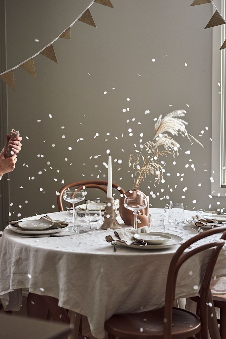 Hoe organiseer je een onvergetelijk feest: Hier zie je een gedekte tafel met een rotje dat net is ontploft en confetti die op tafel valt.