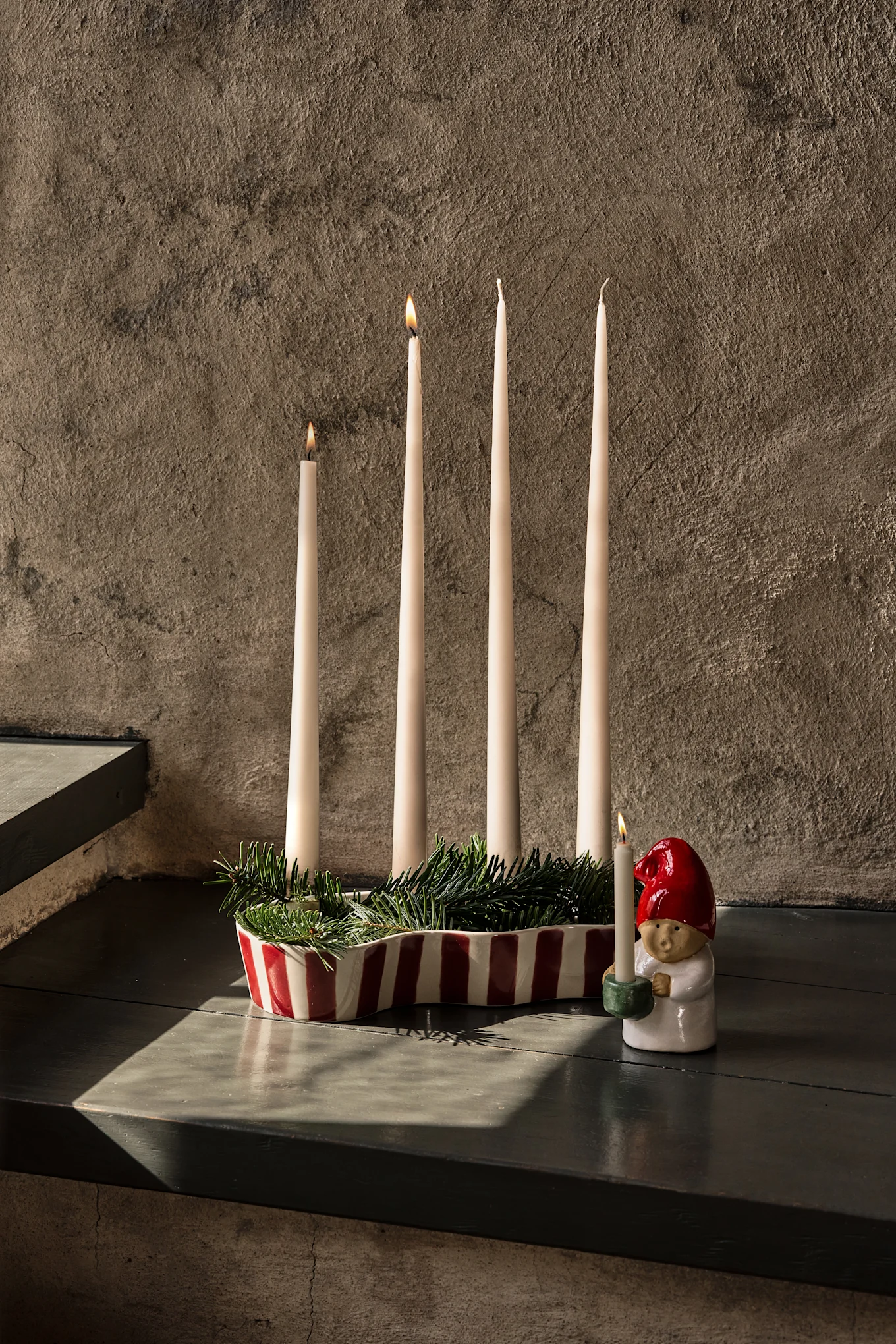 Elegante tafel gedekt met donkerrood tafelkleed, wijnglazen, borden, een etagère met fruit en brandende kaarsen.