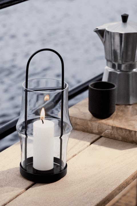 Lantaarns en windlichten voor buiten - hier zie je de Arc lantaarn van Holmegaard buiten staan met een kaars erin.
