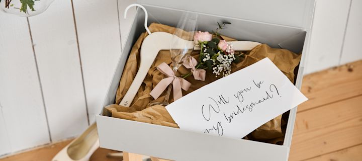 Neem deze unieke trouwideeën op in jullie grote dag, zoals een gepersonaliseerd bruidsmeisje-voorstel met een hanger voor de jurk, een champagneglas en een handopbergdoos. 