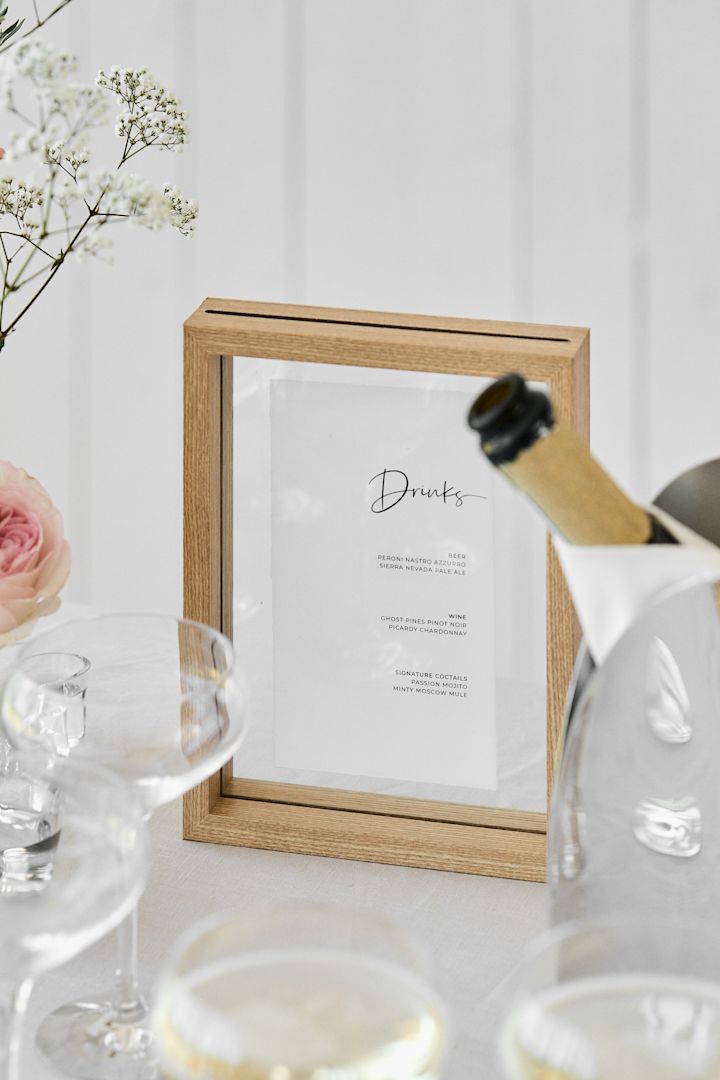 Hier zie je een gedekte drankjes tafel, waar is ingezoomd op de ingelijst menukaart.