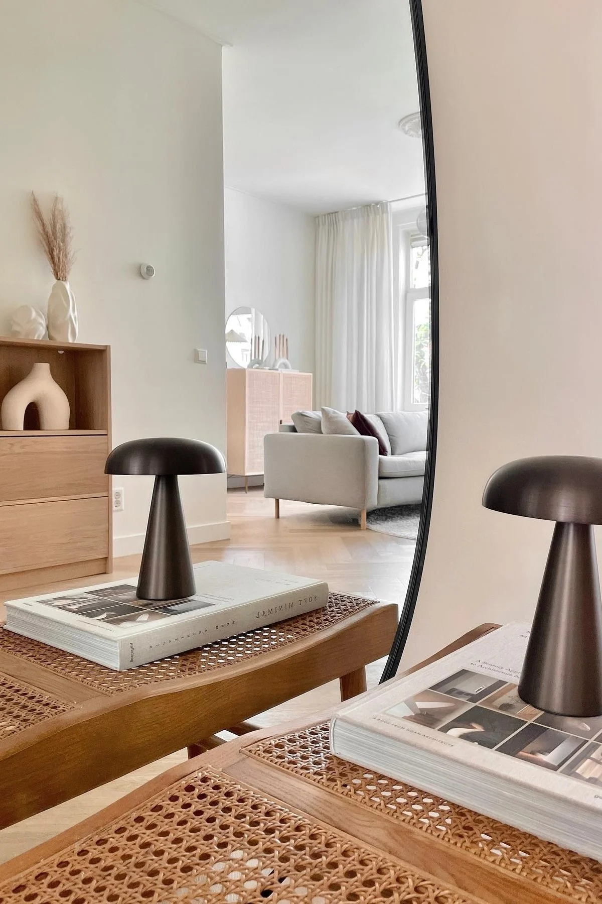 Hier zie je de Como draagbare lamp van &tradition op een boek staan in een strakke, opgeruimde woonkamer in Japanse stijl.  