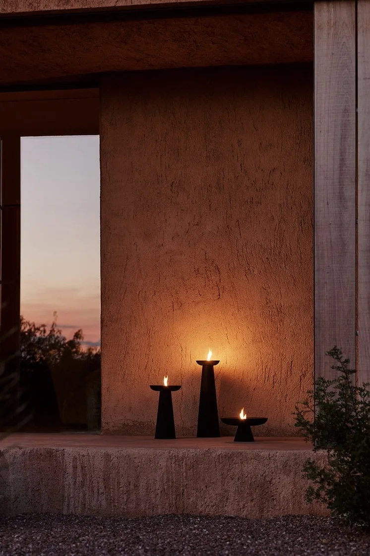 Verlicht je entree met buitenlantaarns en windlichten en plaats de Meira olielantaarn van Audo Copenhagen, die verkrijgbaar is in verschillende maten, buiten.