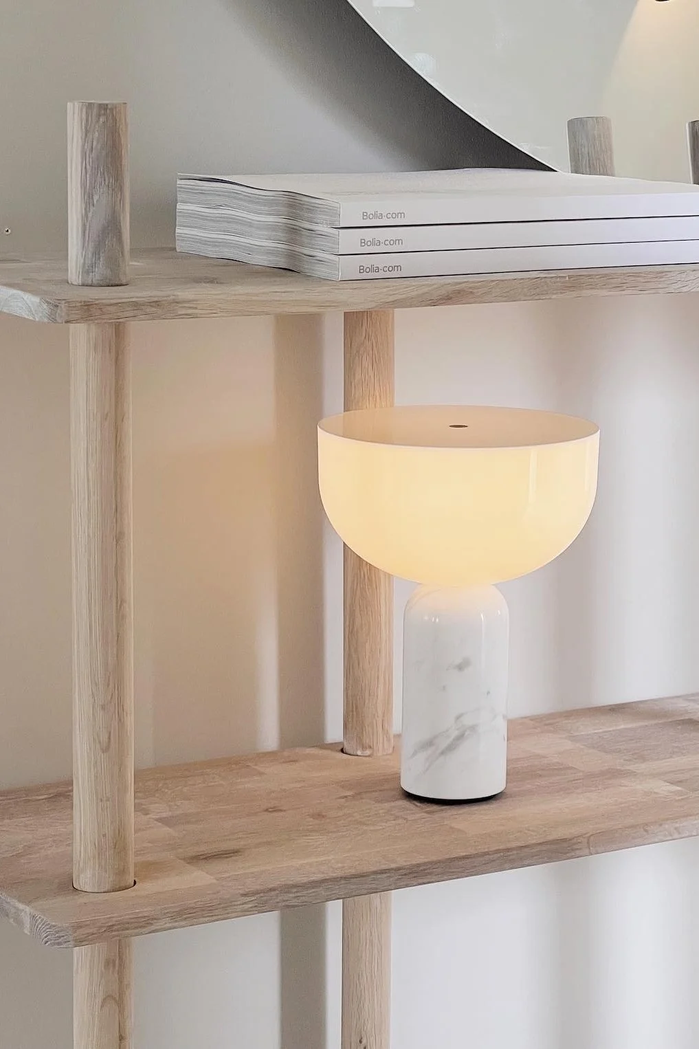 Boho en andere interieurstijlen: Hier zie je een Kizu tafellamp van New Works op een lichte plank in het huis van Instagram-gebruiker @ayasinteriorworld.