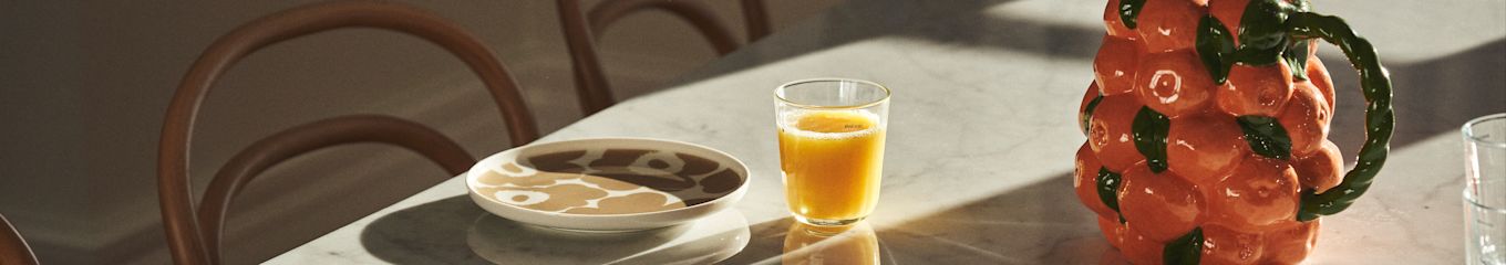 Hier zie je een gedekte tafel met Marimekko servies, sap en karaf van BYON in het ontwerp van mandarijnen. 