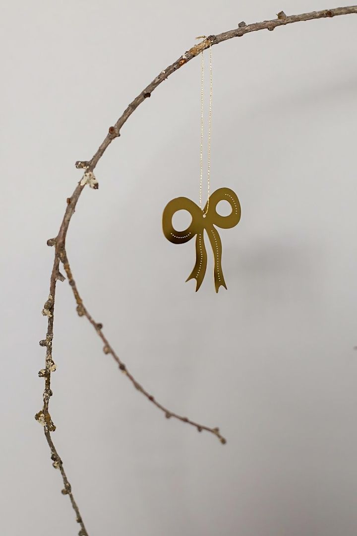 Kerstdecoratie 2025: De gouden Missia-decoratiehanger van Lene Bjerre hangt aan een muur.