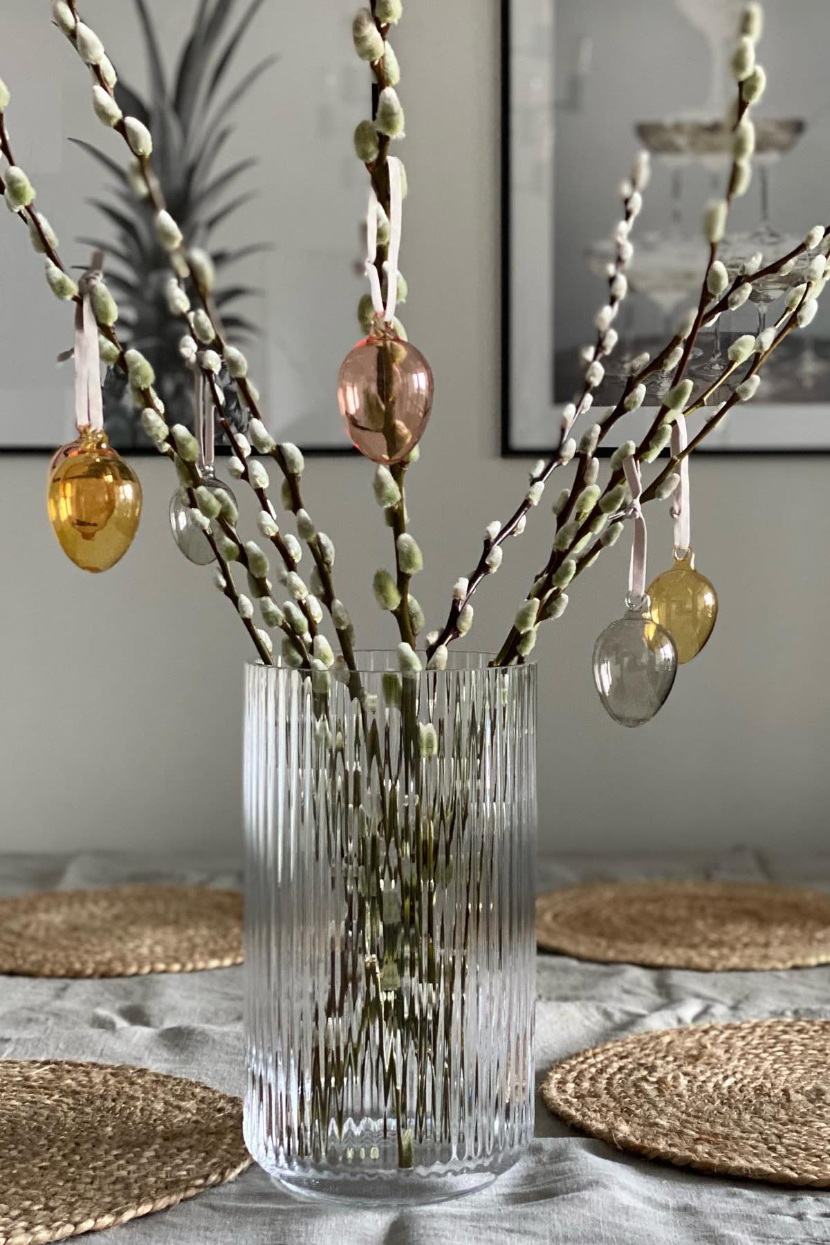 Paasdecoratie: De glazen eieren van Iittala hangen aan een paastak in een glazen vaas van Lyngby Porcelaen in het huis van @marinaslgh.