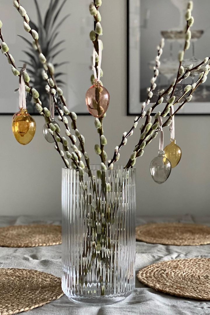 Paasdecoratie: De glazen eieren van Iittala hangen aan een paastak in een glazen vaas van Lyngby Porcelaen in het huis van @marinaslgh.
