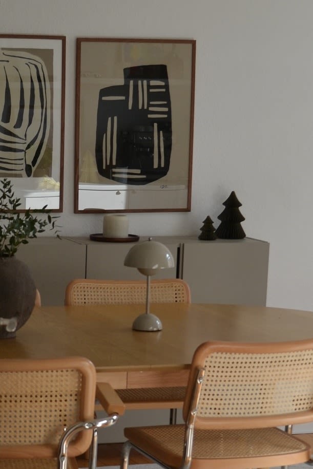 Greige komt terug in de kleurtrends voor 2025, hier zie je de Flowerpot VP9 draadloze lamp van &Tradition op een houten eettafel. 